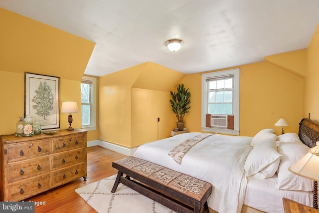 bedroom featuring lofted ceiling, cooling unit, light wood-type flooring, and multiple windows