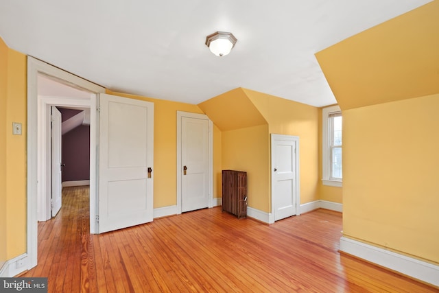 additional living space featuring light hardwood / wood-style flooring and lofted ceiling