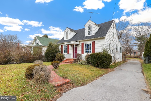 cape cod-style house featuring a front lawn