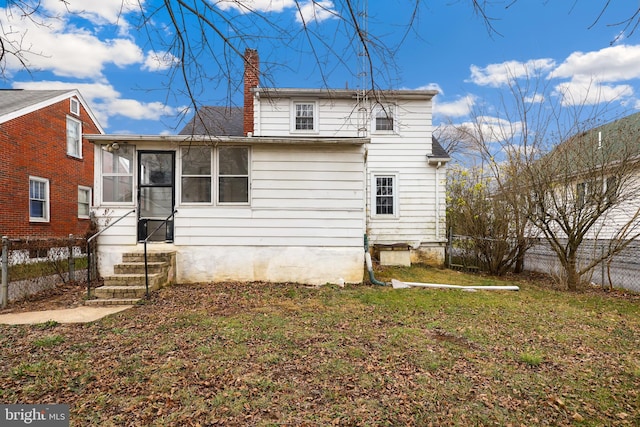 rear view of house with a sunroom and a lawn