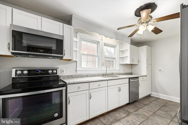 kitchen featuring white cabinets, sink, ceiling fan, light tile patterned floors, and stainless steel appliances