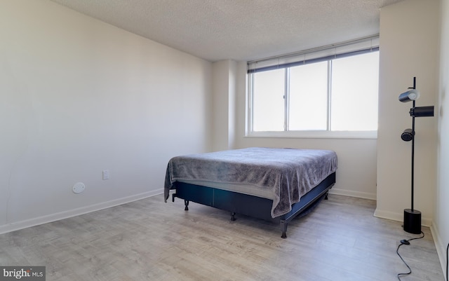 bedroom featuring a textured ceiling and light wood-type flooring