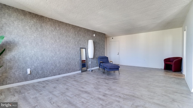 unfurnished room featuring a textured ceiling and light wood-type flooring