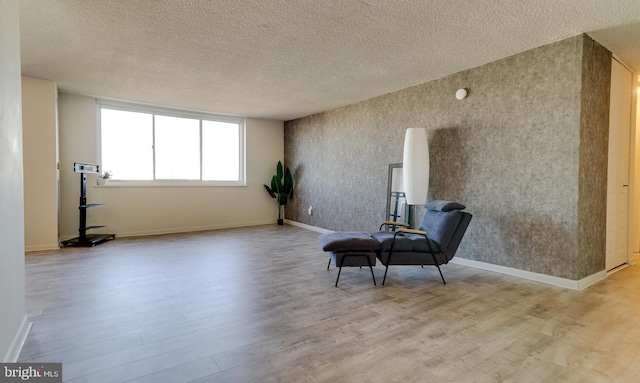 sitting room with a textured ceiling and light hardwood / wood-style flooring