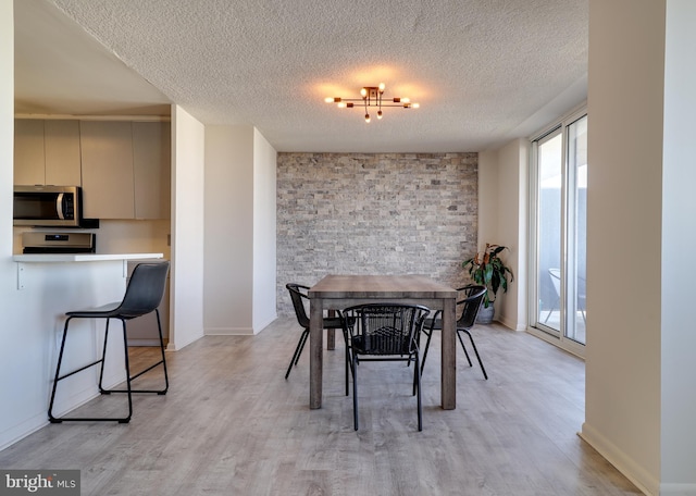 dining area featuring light hardwood / wood-style floors and a textured ceiling