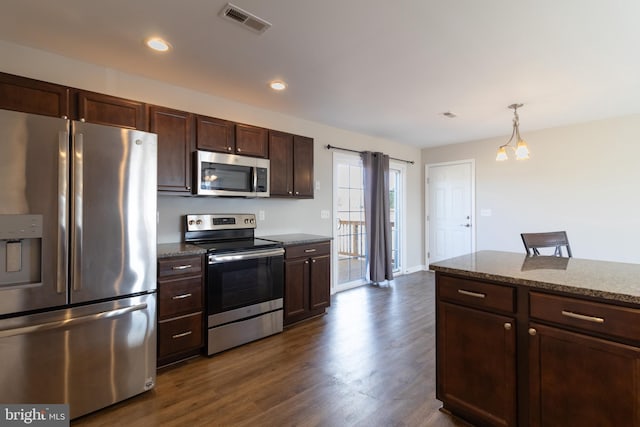 kitchen with pendant lighting, stainless steel appliances, light stone counters, and dark hardwood / wood-style floors