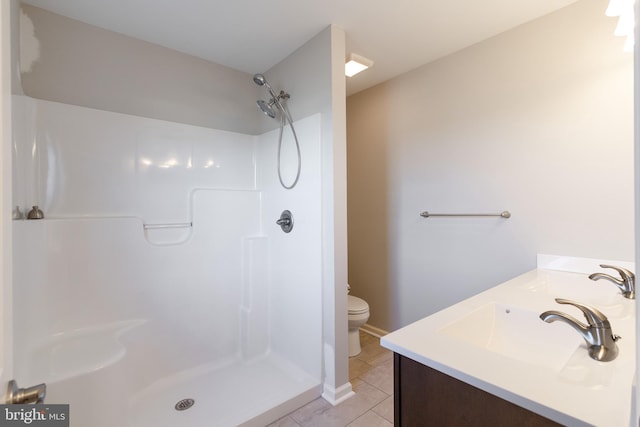 bathroom with a shower, tile patterned flooring, vanity, and toilet