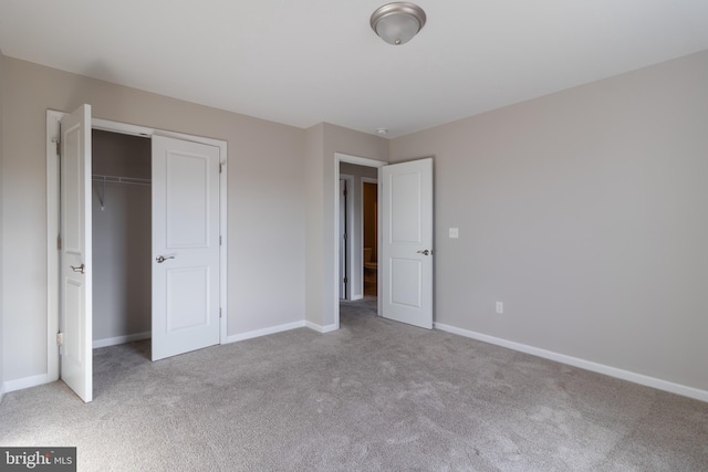 unfurnished bedroom with light colored carpet and a closet