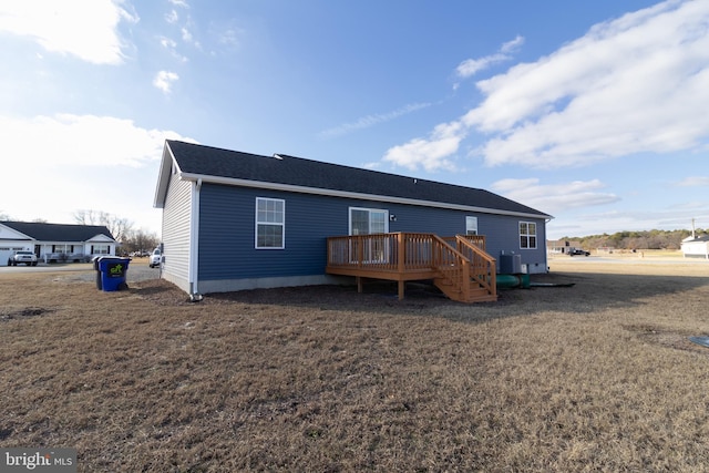 back of house featuring a yard and a wooden deck