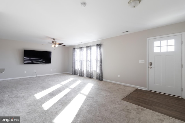 foyer featuring ceiling fan and carpet floors