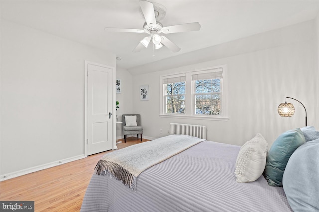 bedroom with radiator, hardwood / wood-style flooring, and ceiling fan