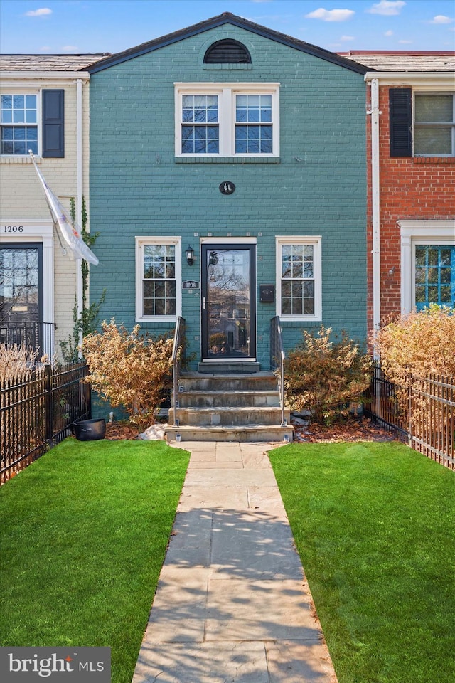 townhome / multi-family property featuring a front lawn