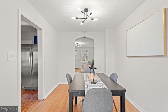 dining room with hardwood / wood-style flooring and a notable chandelier