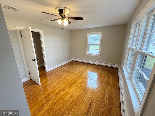 empty room featuring ceiling fan, a baseboard radiator, and light hardwood / wood-style floors