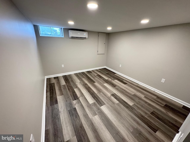 basement featuring wood-type flooring and an AC wall unit