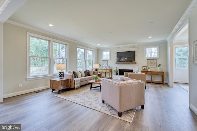 living room with crown molding, a fireplace, and light hardwood / wood-style flooring