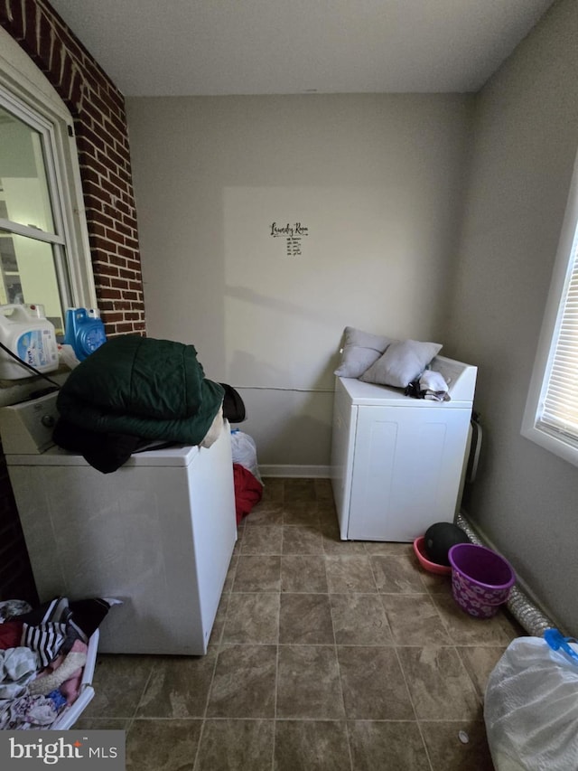 washroom featuring washer / dryer and brick wall