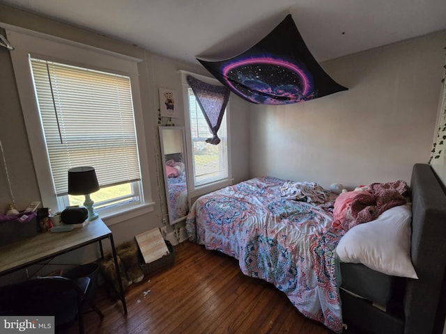 bedroom with dark hardwood / wood-style flooring