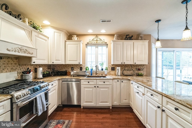 kitchen featuring sink, hanging light fixtures, dark hardwood / wood-style flooring, white cabinetry, and stainless steel appliances