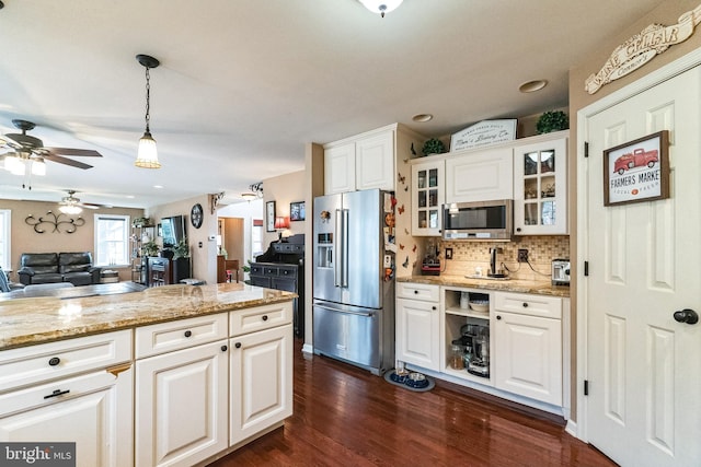 kitchen with hanging light fixtures, light stone countertops, appliances with stainless steel finishes, dark hardwood / wood-style flooring, and white cabinetry