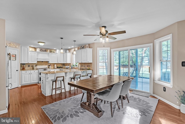 dining room featuring ceiling fan, light wood-type flooring, and sink