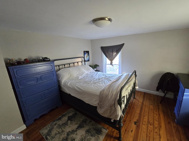 bedroom with dark hardwood / wood-style floors