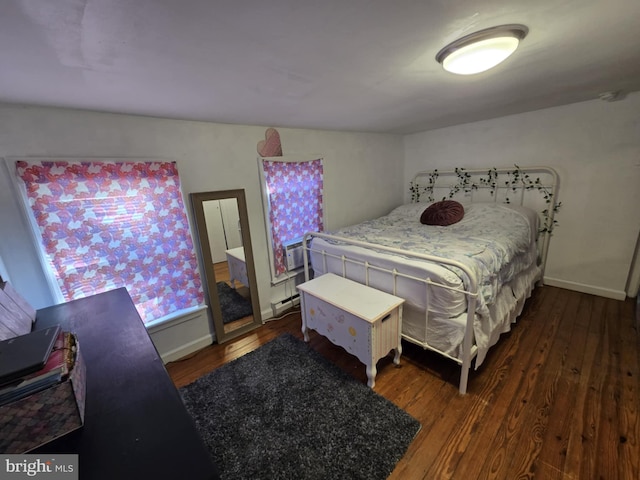 bedroom with cooling unit, dark wood-type flooring, and a baseboard radiator