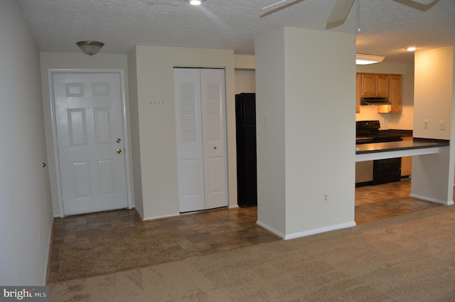 kitchen with black appliances, ceiling fan, a textured ceiling, and dark colored carpet