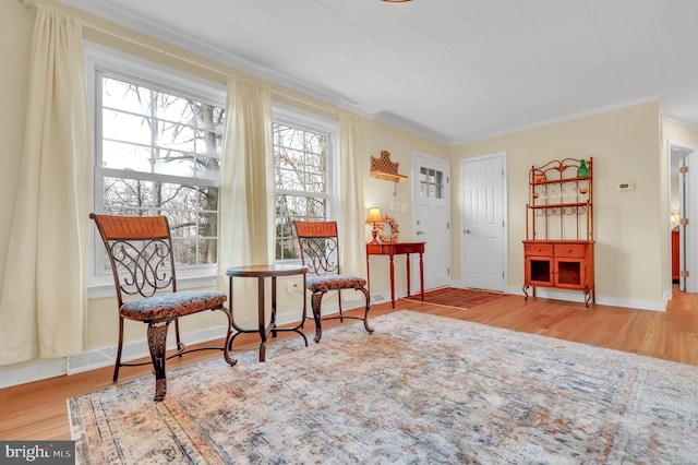 living area featuring hardwood / wood-style flooring and ornamental molding