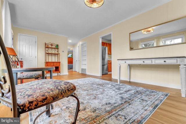 living area featuring light hardwood / wood-style floors and ornamental molding