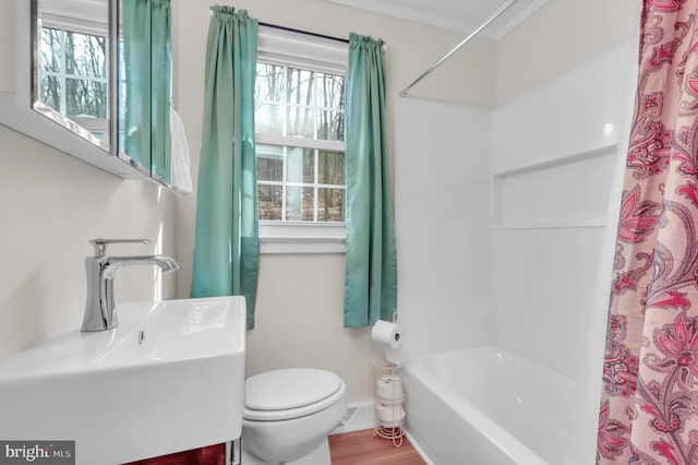 full bathroom with toilet, shower / bathtub combination with curtain, crown molding, and sink