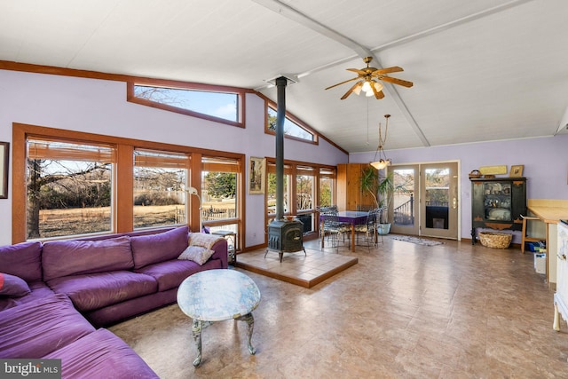 living room featuring high vaulted ceiling, a wood stove, a wealth of natural light, and ceiling fan