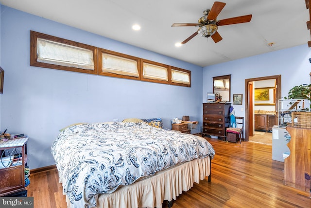 bedroom featuring hardwood / wood-style floors, ceiling fan, and connected bathroom