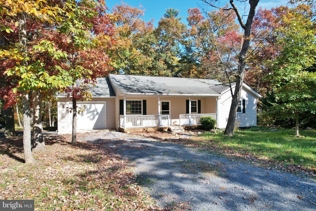 ranch-style house with a porch and a garage