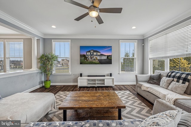 living room featuring dark hardwood / wood-style floors, plenty of natural light, ornate columns, and ornamental molding