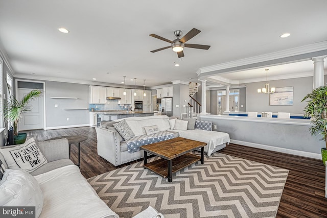 living room featuring dark hardwood / wood-style floors, crown molding, and ceiling fan with notable chandelier