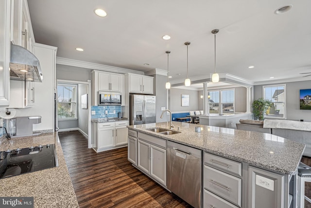 kitchen featuring pendant lighting, a center island with sink, white cabinets, sink, and stainless steel appliances