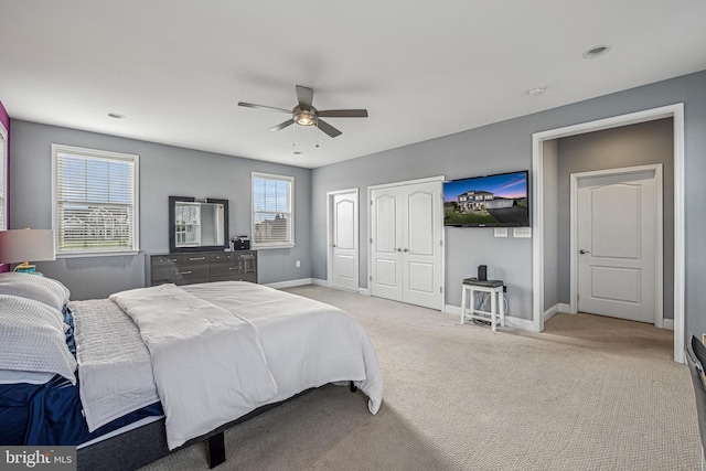 carpeted bedroom with multiple windows, a closet, and ceiling fan