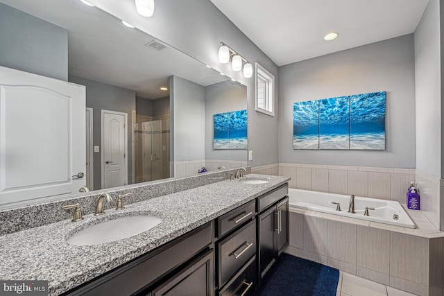 bathroom featuring plus walk in shower, vanity, and tile patterned floors