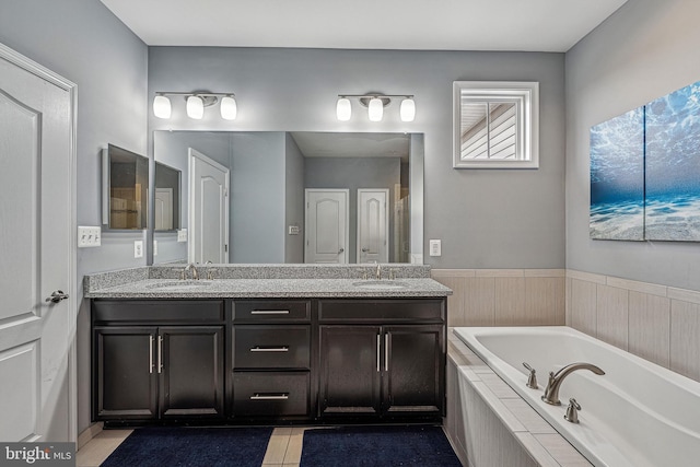 bathroom featuring tile patterned floors, tiled tub, and vanity