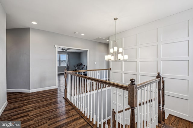 stairway with a chandelier and hardwood / wood-style flooring