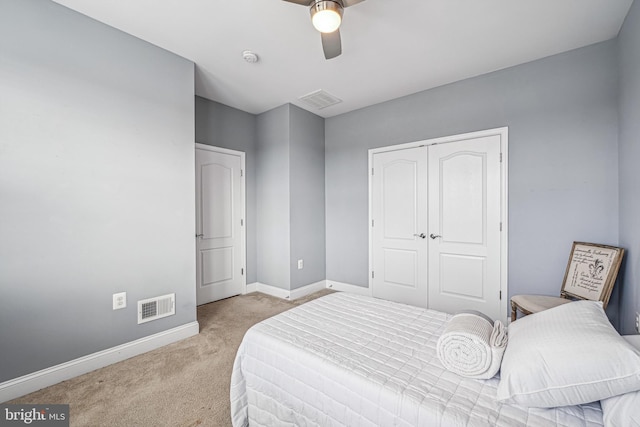 carpeted bedroom featuring a closet and ceiling fan