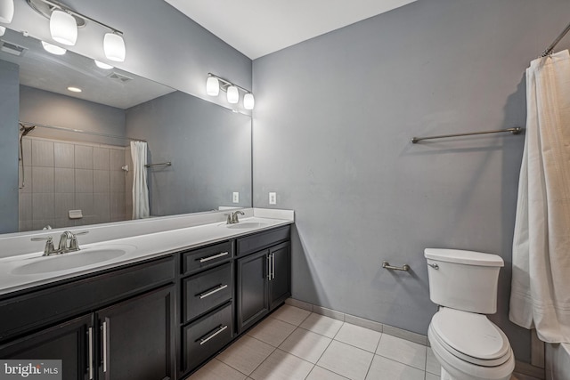 bathroom with tile patterned flooring, vanity, toilet, and walk in shower