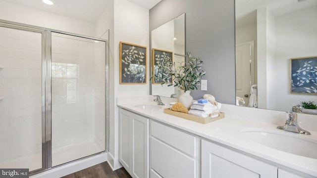 bathroom with a shower with door, vanity, and hardwood / wood-style flooring