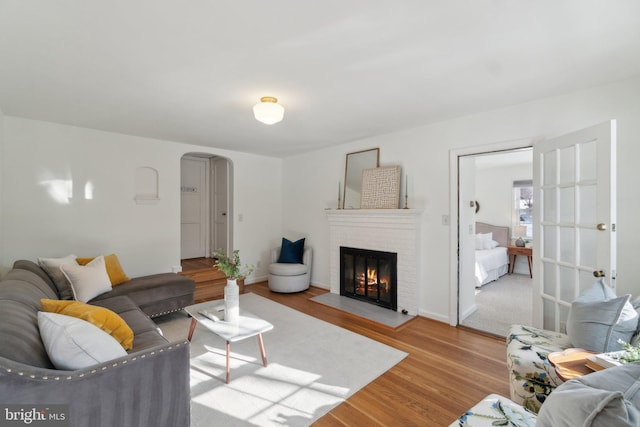 living room featuring a brick fireplace and light hardwood / wood-style flooring