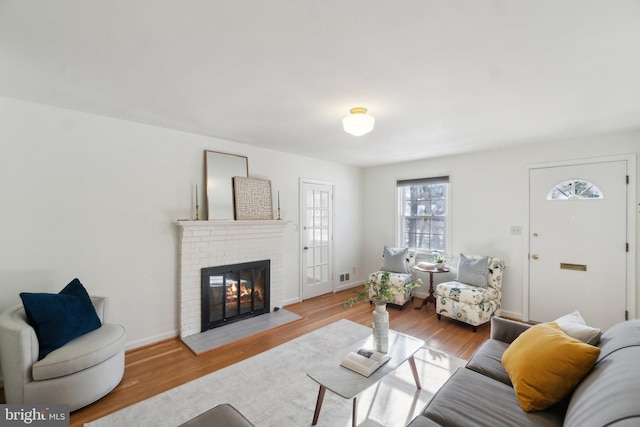 living room featuring light hardwood / wood-style floors and a brick fireplace