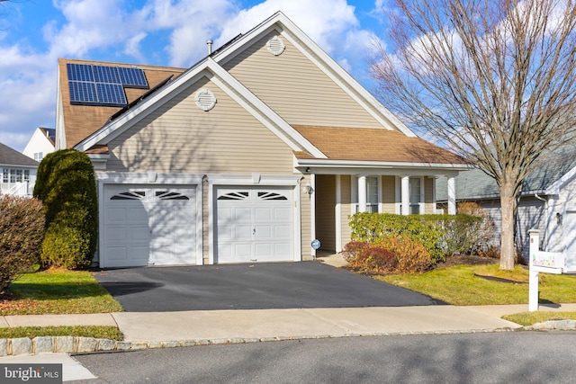 view of front facade featuring solar panels and a garage