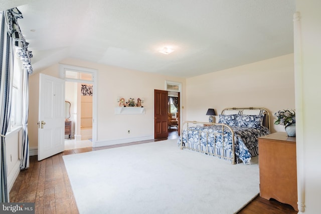 bedroom with wood-type flooring and vaulted ceiling