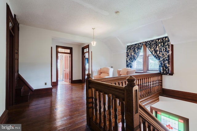 bedroom featuring a textured ceiling, a crib, vaulted ceiling, and dark hardwood / wood-style floors