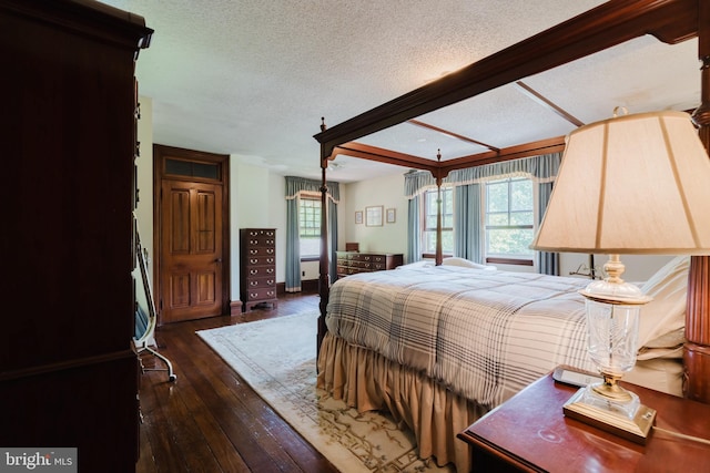 bedroom featuring dark hardwood / wood-style flooring and a textured ceiling